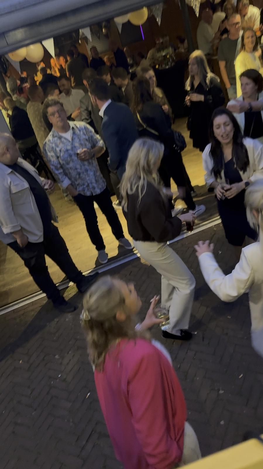 Gasten dansen voor de bus