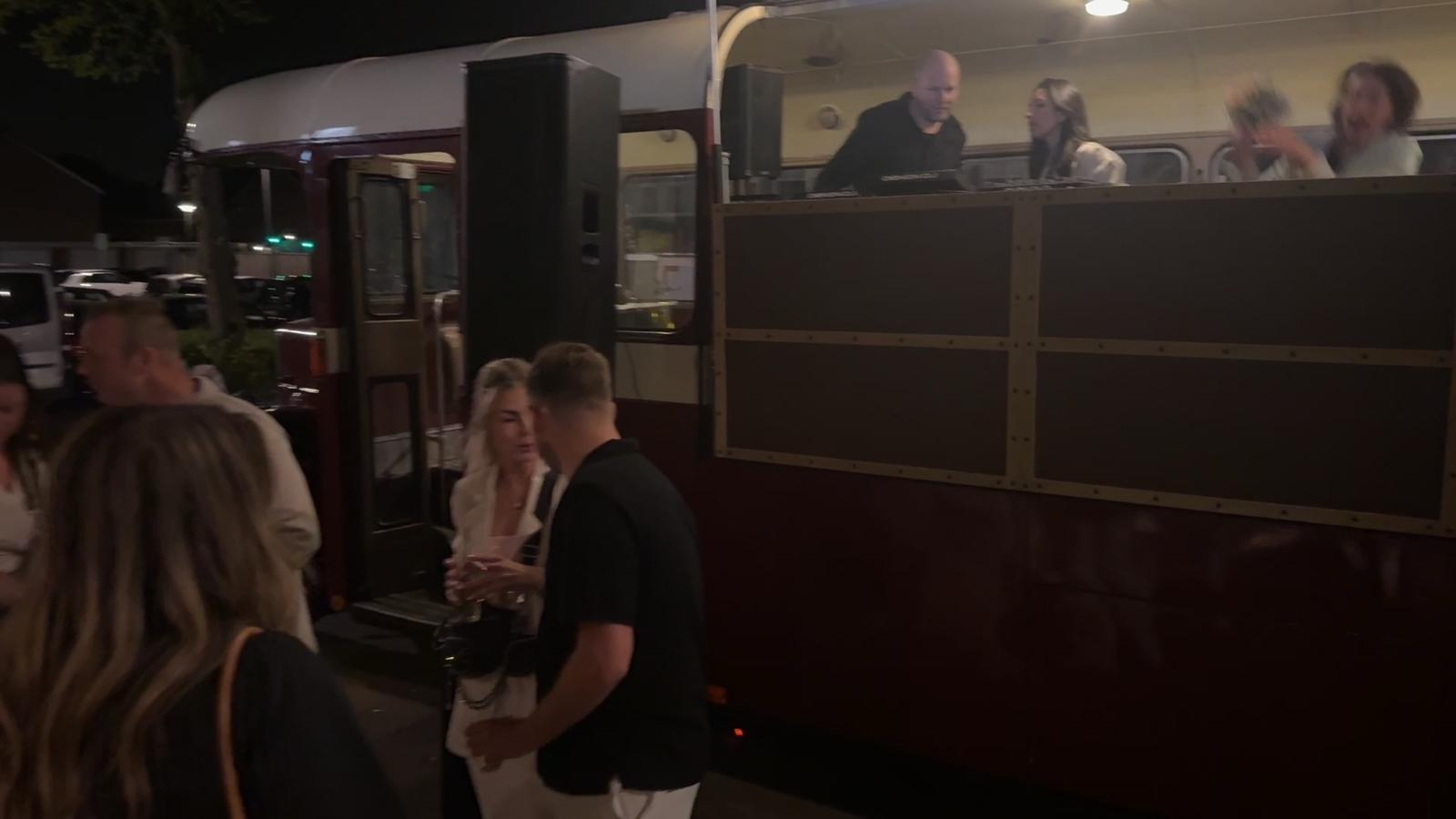 Feest onder de slingers met de bus op de achtergrond