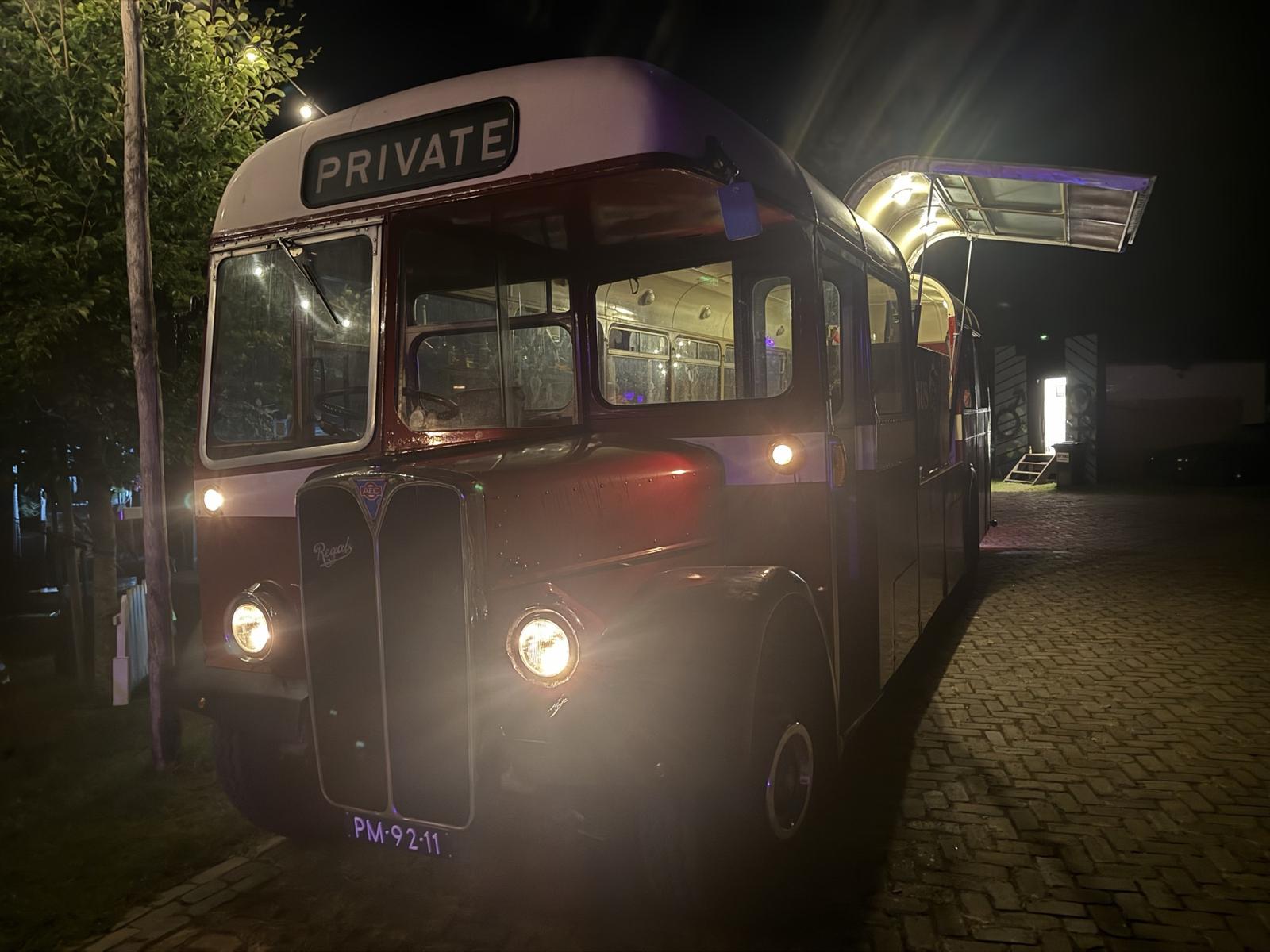 De bus met brandende lampen in de nacht