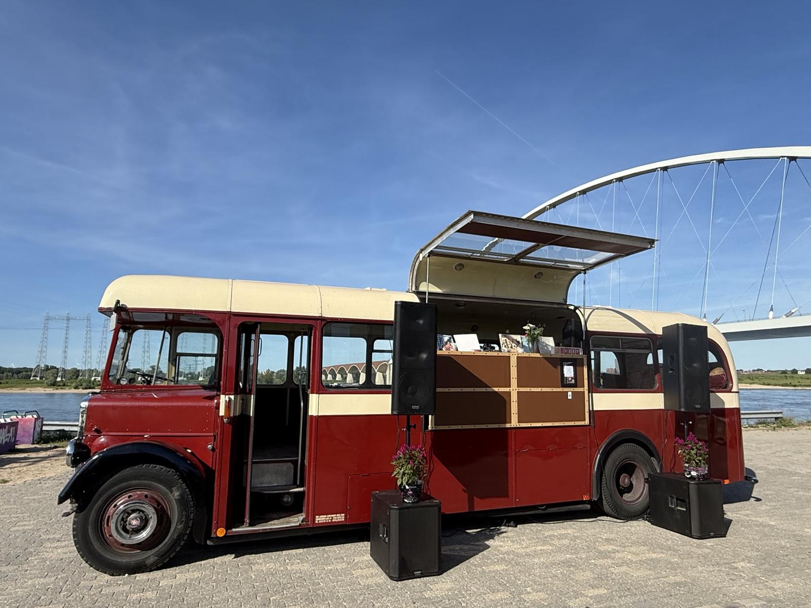 De bus met open luifel en DJ meubel aan de Waal