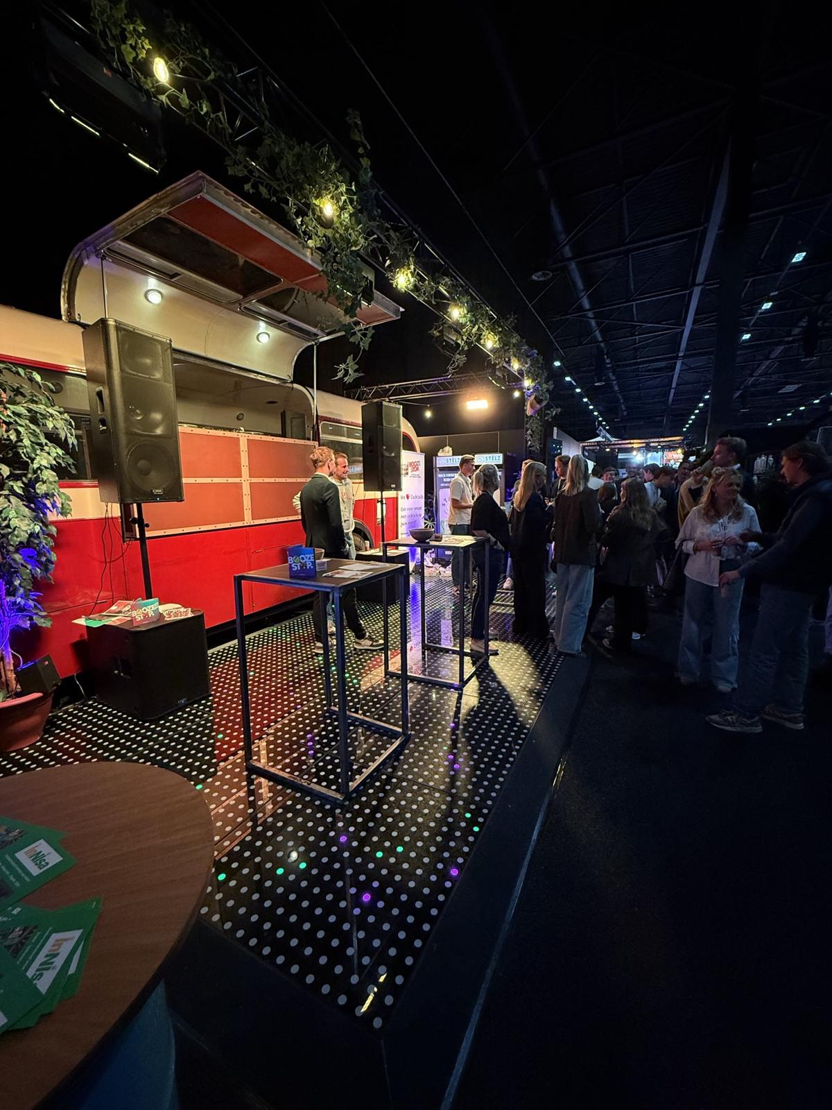 Beursbezoekers rond de bus